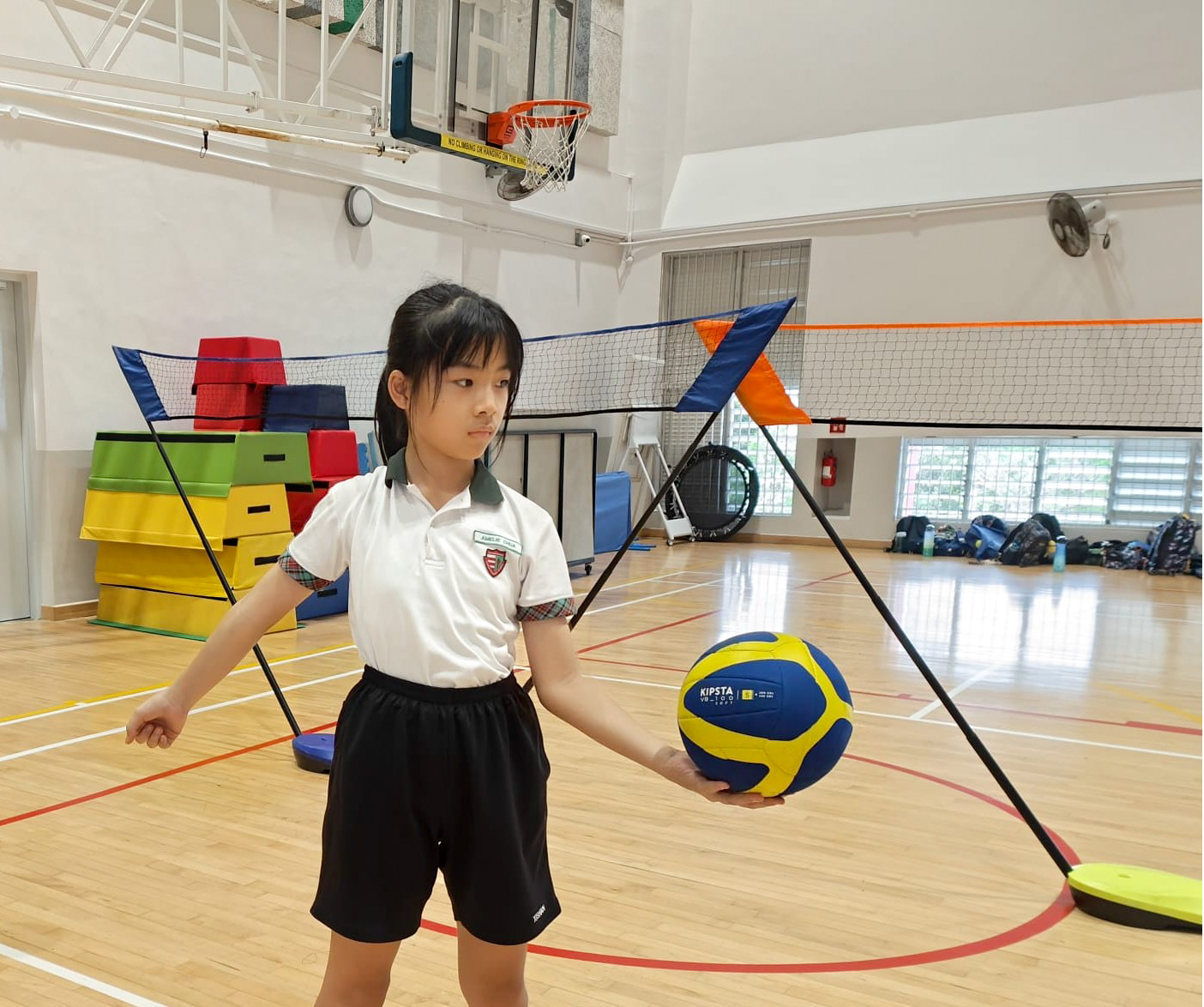 Student practising her volleyball serve